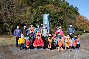 仙台市視覚障害者ランニングクラブの旗の前で整列するメンバー