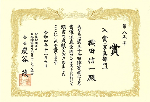 入賞（写真部門）のタイトルに小田さんの名前と本文、令和4年12月9日の日付と炭谷会長の名前が縦書きに書いてある賞状